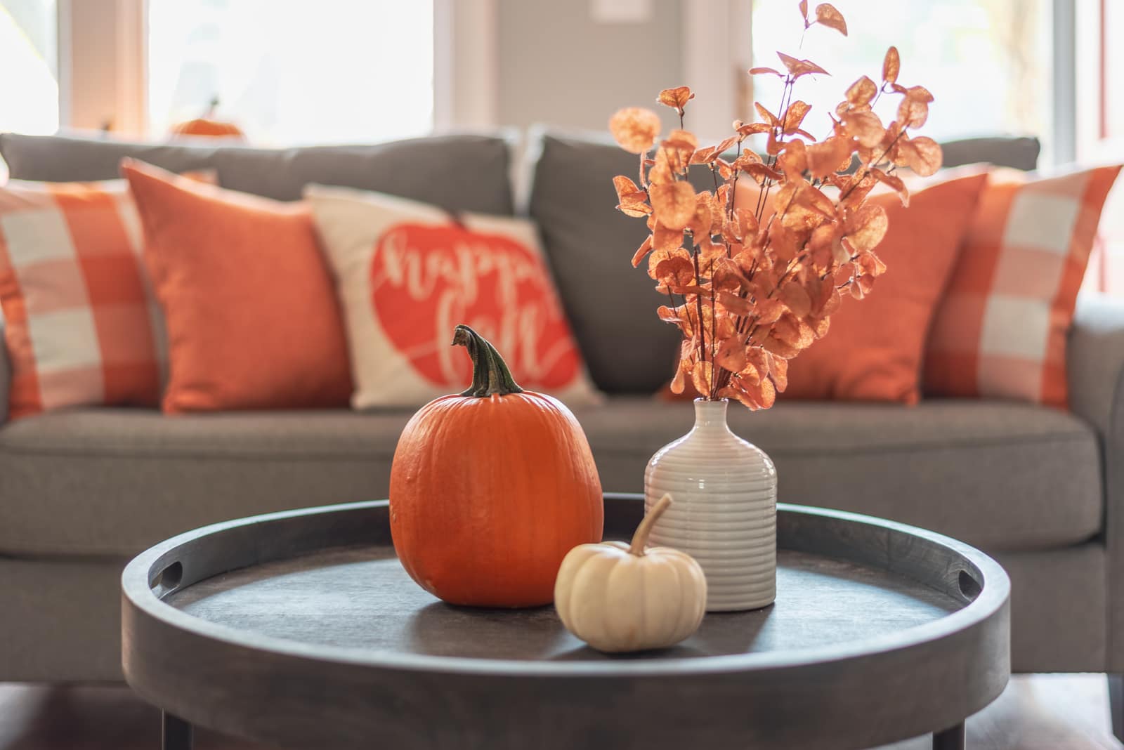 Tidy living room with fall pumpkins and flowers on the coffee table