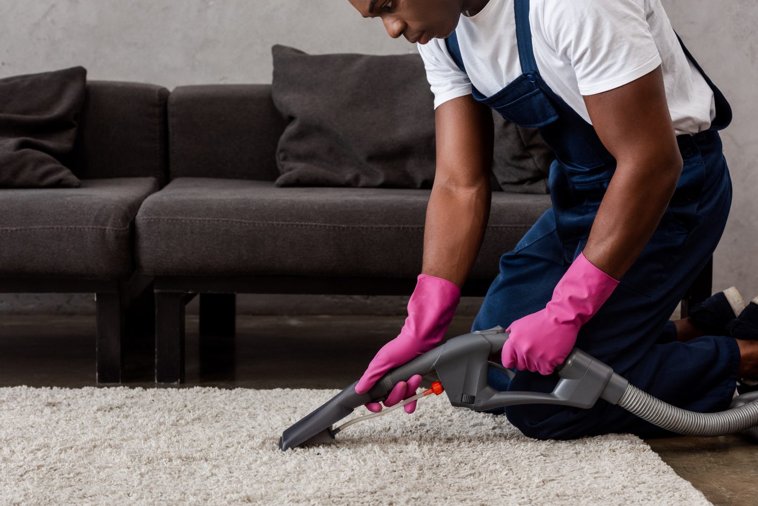Cropped view of african american cleaner using vac
